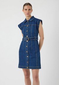 Denimkjole med kortermede ermer, kragehals, knappestolpe foran og belte i midjen. Mørkeblå farge med synlige sømdetaljer.