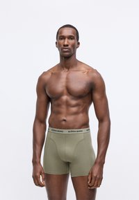 Olíva zöld boxer alsók fekete 'BJÖRN BORG' felirattal ellátott derékpánttal, feszes fazonban és puha, texturált anyagból.