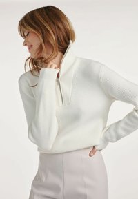 Biały sweter z prążkowanego dzianiny z pół-zapięciem, z długimi rękawami i wysokim kołnierzem. Gładka textura z dopasowanym krojem.