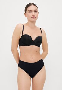 Sort bh med underwire, glatte skål og justerbare stropper, parret med matchende højtaljede trusser. Begge genstande har et sømløst design.