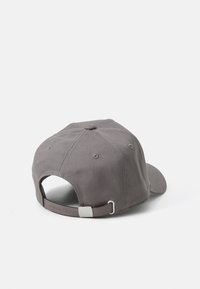 Grå caps med buet skjerm, justerbar stropp bak med metallhardware og et teksturert bomullslignende materiale.
