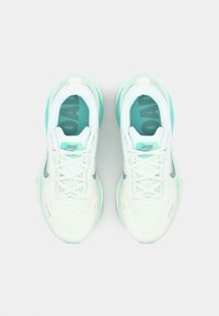 Weiße und mintgrüne Sportschuhe mit einem Mesh-Obermaterial, runder Zehenpartie, Schnürdesign und strukturierten Sohlen. Auffälliges Logo an den Seiten.