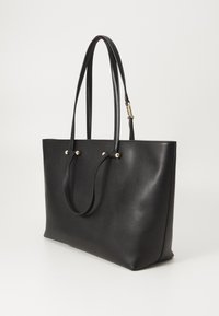 Borsa tote in pelle nera con due manici lunghi, design minimalista, texture liscia e dettagli in metallo dorato vicino ai manici.