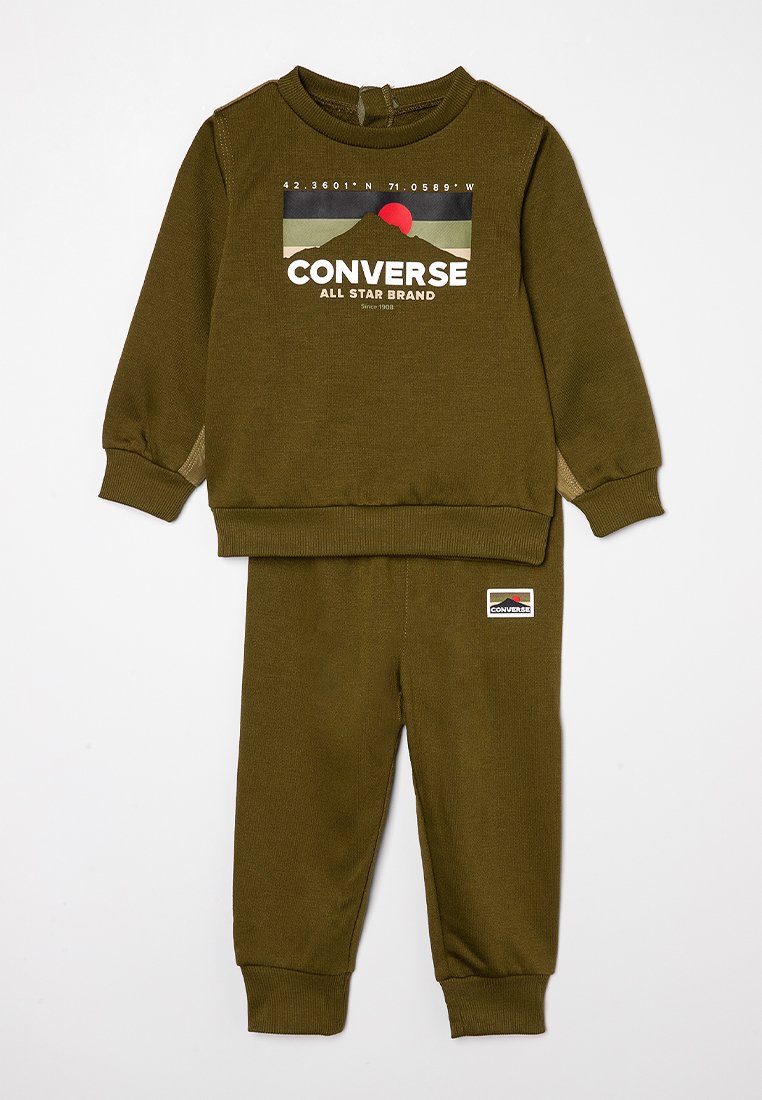 Ensemble de sweatshirt et pantalon vert olive, fabriqué dans un matériau doux. Le sweatshirt arbore un graphique de logo ; le pantalon est doté d'un patch logo sur la jambe.
