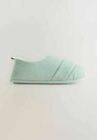 Mint green slipper with a textured fabric upper, rounded toe, and a flat sole. Features stitching details and a small back tab for easy wear.