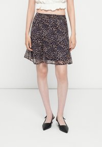 Gonna fluida blu navy con un motivo floreale, presenta una vita elastica, un taglio al ginocchio e una sovrapposizione trasparente e testurizzata.