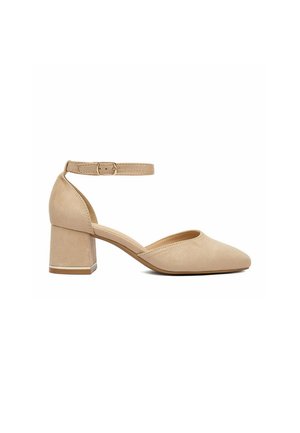 Dámská béžová semišová obuv se zaoblenou špičkou, blokovým podpatkem a páskem kolem kotníku se zapínáním na sponu na bílém pozadí.