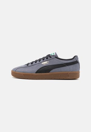 Baskets Puma Delphin grises avec bande noire, semelle en gomme, design à lacets et logo Puma contact sur le côté.