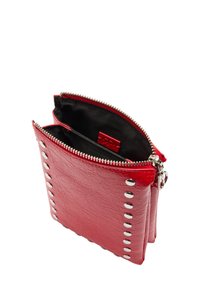 Czerwona skórzana saszetka z zamkiem błyskawicznym, z metalowymi ćwiekami po jednej stronie i czarnym materiałowym wnętrzem. Dwa przegródki w środku.