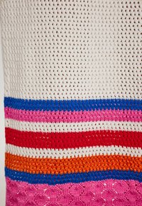 Gehaakt textiel met een witte achtergrond en meerkleurige horizontale strepen in rood, roze, blauw, oranje en ingewikkelde patronen.