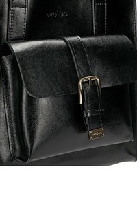 Czarna skórzana plecak z przednią klapą i złotą metalową klamrą. Posiada teksturowaną powierzchnię i wytłoczone logo. Prosty, zorganizowany design.