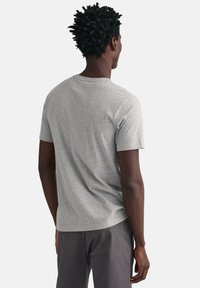 Grijze T-shirt met korte mouwen en een ronde hals, gemaakt van zachte stof, met een ontspannen pasvorm en subtiele stiksels langs de randen.