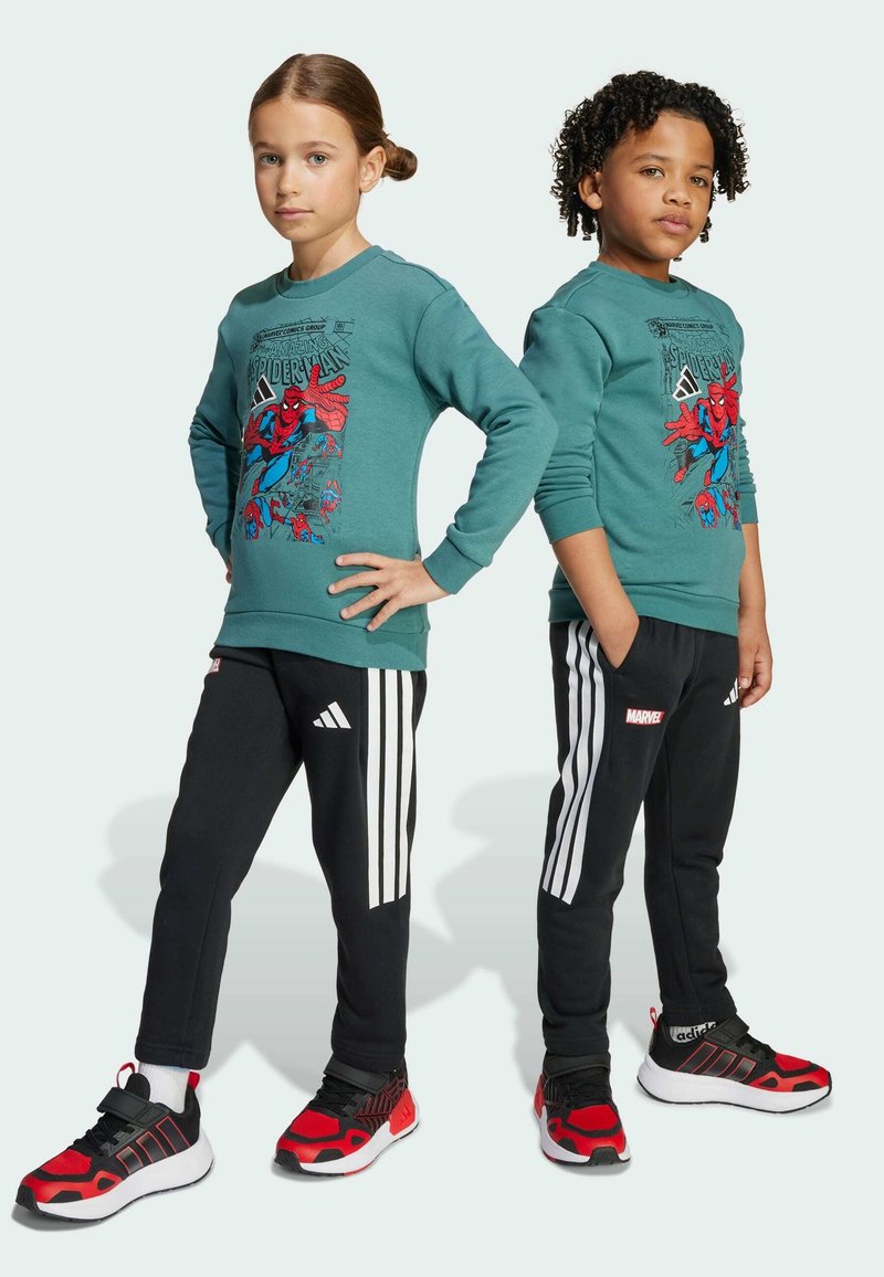 Felpa turchese con grafica di Spider-Man; pantaloni neri con strisce bianche; scarpe da ginnastica rosse e nere. Design unisex adatto ai bambini.