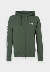 Groen zip-up hoodie gemaakt van zachte stof, voorzien van een capuchon met trekkoord, voorzakken en witte logotekst op de linkermouw.