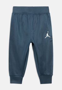 Σκούρες μπλε αθλητικές παντελόνες με υφή, ελαστική μέση και ριμπ μανσέτες. Διαθέτουν λευκό λογότυπο Jumpman στην αριστερή πλευρά.