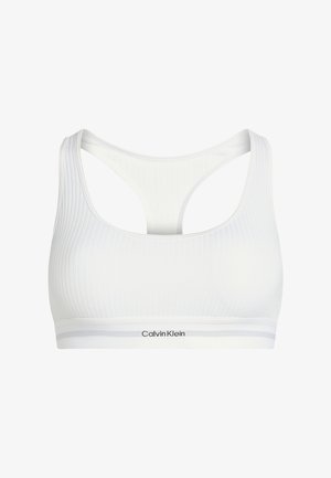 Soutien-gorge de sport blanc à côtes avec un design dos nageur, des bretelles fines et une bande élastique marquée "Calvin Klein" en lettres noires.
