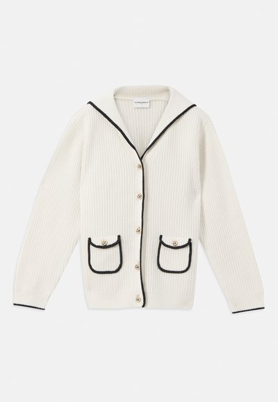 Kremowy kardigan o prążkowanej strukturze z dużym szalowym kołnierzem, czarnymi wykończeniami, złotymi guzikami oraz dwoma przednimi kieszeniami z kontrastującymi krawędziami.