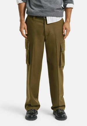 Olijfgroene cargobroek met twee zijzakken, een losse pasvorm en een rechte pijpdesign. Draagt een grijze trui en zwarte schoenen.