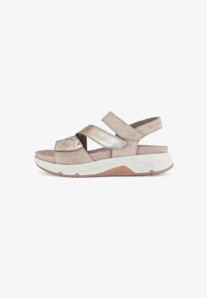 Beige suede sandal with metallic accents, wide adjustable straps, and a cushioned white sole. Features a textured panel on the front.