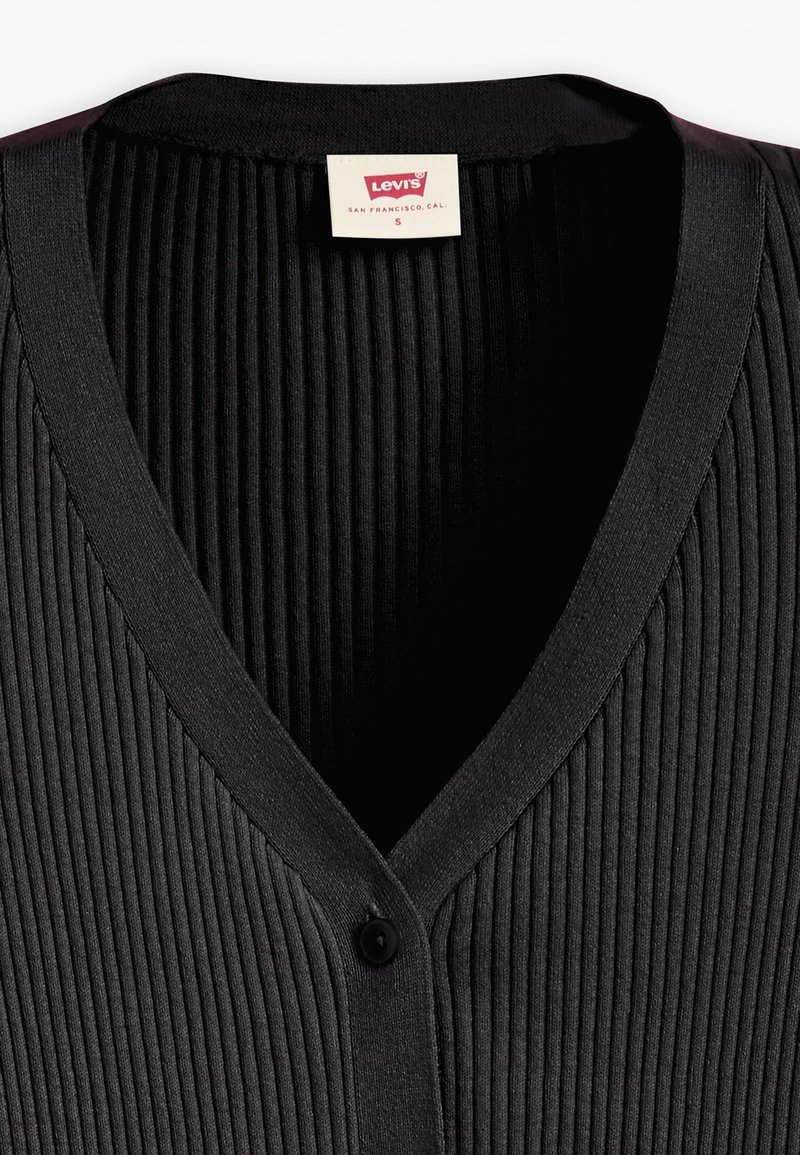 Schwarze gerippte Strickjacke mit V-Ausschnitt-Design, ausgestattet mit einem einzelnen Knopfverschluss. Weicher Stoff mit einem leichten Glanz, hergestellt aus Jersey-Material.