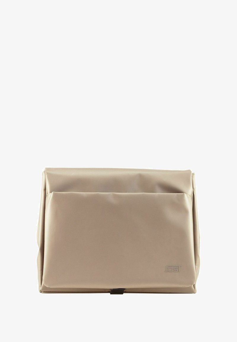 Beige waterproof bag with a structured design, featuring a front flap and subtle embossed logo. Smooth texture and foldable shape.