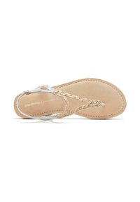 Sandalia plana tipo chancla con una plantilla beige, tiras trenzadas plateadas adornadas con pequeñas cuentas y acentos de hardware plateado minimalistas.