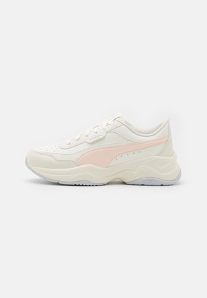 Crème sneaker met een roze accent, bovenmateriaal van textuurleer en mesh, ronde zool en geperforeerde details op de neus.