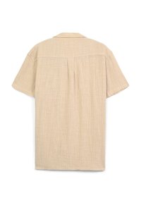 Camicia beige a maniche corte realizzata in tessuto strutturato, con colletto, caratterizzata da una piega posteriore e design a vestibilità rilassata.