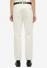 Pantalones de mezclilla blanca con un corte recto, que cuentan con dos bolsillos traseros y un cinturón negro. Textura suave, diseño minimalista.