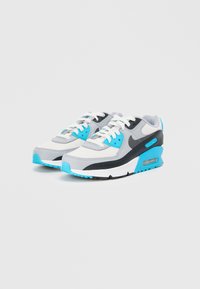 Nike Air Max 90 tenisice imaju kombinaciju sive, bijele i crne mrežaste i sintetičke tkanine, s plavim akcentima i vidljivim zračnim jastučićima.