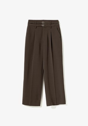 Hnědé široké kalhoty z hladké látky. Mají dvojitý pás se stříbrnými sponami a přední kapsy. Střih na míru.
