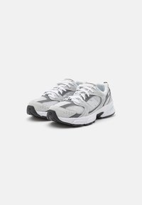 Witte en grijze sneakers met een bovenwerk van mesh en synthetisch materiaal, voorzien van een gevoerde kraag, veters, een luchtgeveerde zool en een gestructureerde rubberen buitenzool.