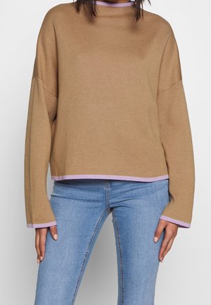 Pull en maille marron avec des manches larges et une coupe décontractée. Présente un liseré lavande au col et à l'ourlet. Porté sur un jean bleu.