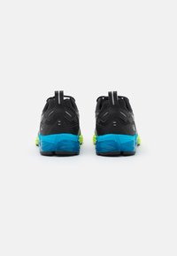 Scarpe da corsa nere con accenti blu e giallo neon, caratterizzate da una parte superiore testurizzata, colletto imbottito e un design distintivo della suola.