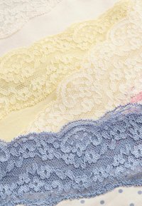 Vier kantafwerkingen zijn te zien: een lichtroze, een bleekgele, een witte en een zachte blauwe. Elke afwerking heeft ingewikkelde bloemmotieven en delicate randen.