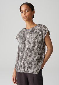 Zwart-wit gestreept T-shirt met korte mouwen en een ronde hals. Lichtgewicht stof met een ontspannen pasvorm en een subtiele textuur.
