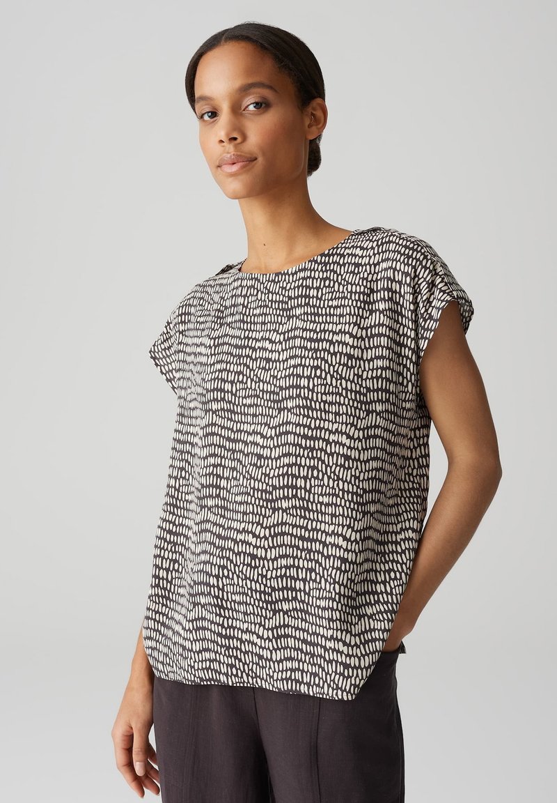 Zwart-wit gestreept T-shirt met korte mouwen en een ronde hals. Lichtgewicht stof met een ontspannen pasvorm en een subtiele textuur.
