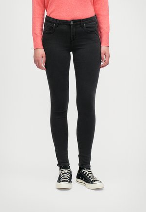 Zwart skinny jeans met vijf-pocketontwerp, voorzien van een knoopsluiting aan de voorkant. Gecombineerd met zwarte canvas sneakers en een felroze trui.