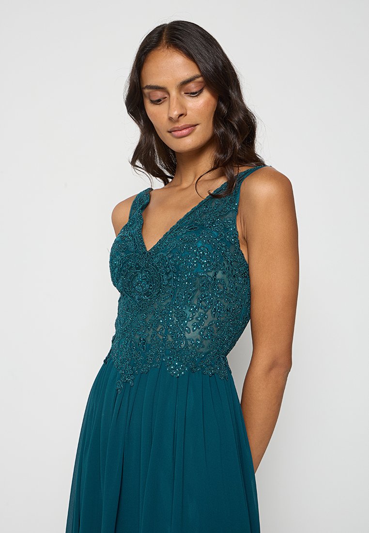 Vestido de noche en color verde azulado con un corsé de encaje con cuentas y detalles florales, tirantes de espagueti ajustables y una falda plisada y fluida.