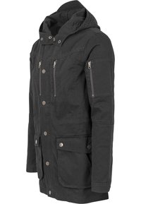Giacca nera con cappuccio, dotata di numerose tasche con zip e bottoni, in un tessuto testurizzato e dal design leggermente oversize.