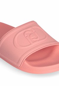 Sandaș cu toc roz, fabricat din cauciuc texturat. Dispune de o curea lată cu un logo debossat și un design cu vârful deschis. Talpa netedă și forma curbată.