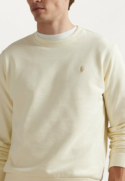 Felpa giallo chiaro in cotone. Girocollo con polsini e orlo a costine. Logo ricamato sul petto a sinistra.