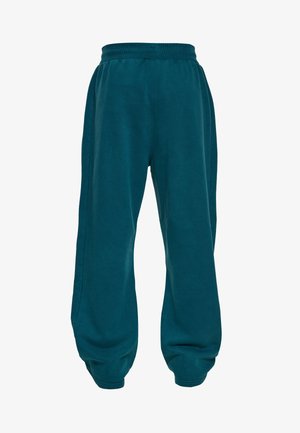 Tume-türkiissinised elastse vöökohaga spordipüksid elastsete äärte ja lõdva, lahtise lõikega.