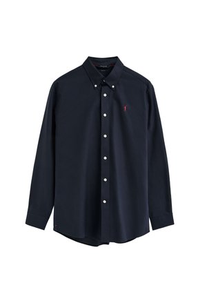 Camisa azul marino de manga larga con botones blancos y un pequeño logo rojo bordado en el pecho izquierdo.