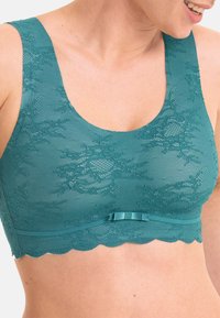 Teal Spitzen-Bralette mit glatter Textur, floralen Mustern, gewelltem Saum und einem kleinen Bandakzent in der Mitte des Bundes.