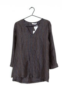 Blusa blu navy con pois dorati, scollo a V e maniche a tre quarti, caratterizzata da una vestibilità ampia e una leggera plissettatura all'orlo.