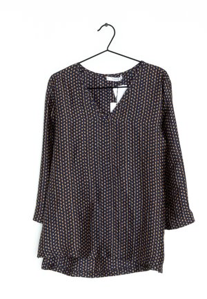 Navyblaue Bluse mit goldenen Pünktchen, V-Ausschnitt und Dreiviertelärmeln, mit lockerer Passform und einem leichten Faltenwurf am Saum.