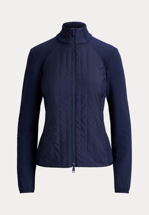 Veste femme bleu marine avec panneau avant matelassé, manches longues, col montant et fermeture éclair frontale.