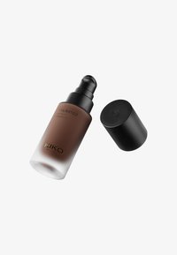 Botella de base marrón con un dosificador negro y tapa. Base de vidrio opaco que se desvanece a transparente. Presenta una etiqueta que dice "KIKO UNLIMITED 24H MATTE FOUNDATION".