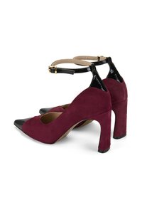 Burgunderfarbene Wildleder-Pumps mit schwarzen Lackleder-Zehenkappen und Knöchelriemen, die an den Seiten eine abgerundete Aussparung und eine goldene Schnalle aufweisen.